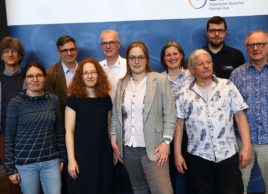 Landesvorstand 2025 Der Landesvorstand des ADFC NRW, bestehend aus 10 Personen, steht vor einer Stellwand mit ADFC-NRW-Branding.